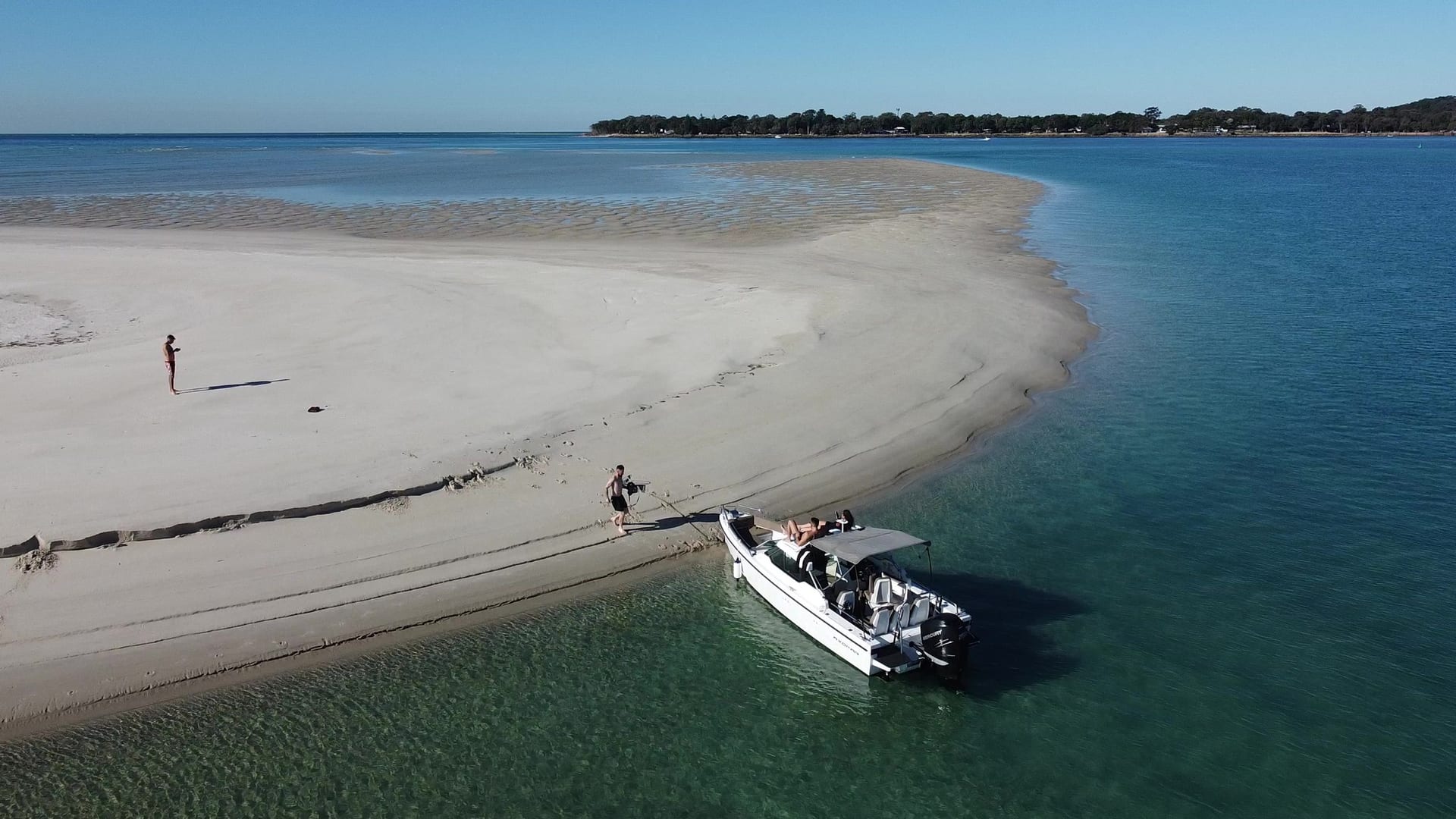 A couple with the Sea La Vie boat on a quiet Moreton Bay beach