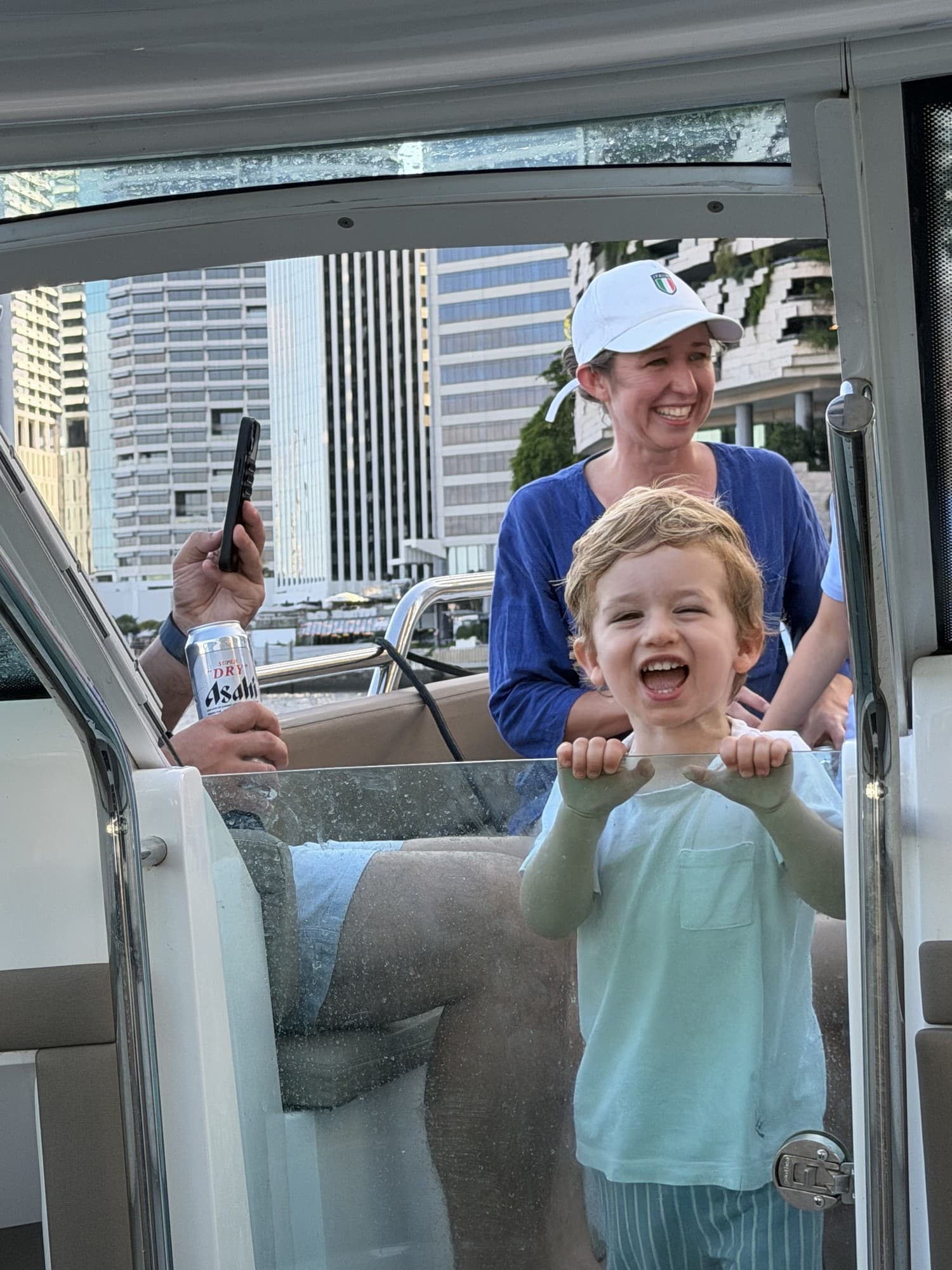 A delighted toddler holding the boat windscreen as the charter cruises the river