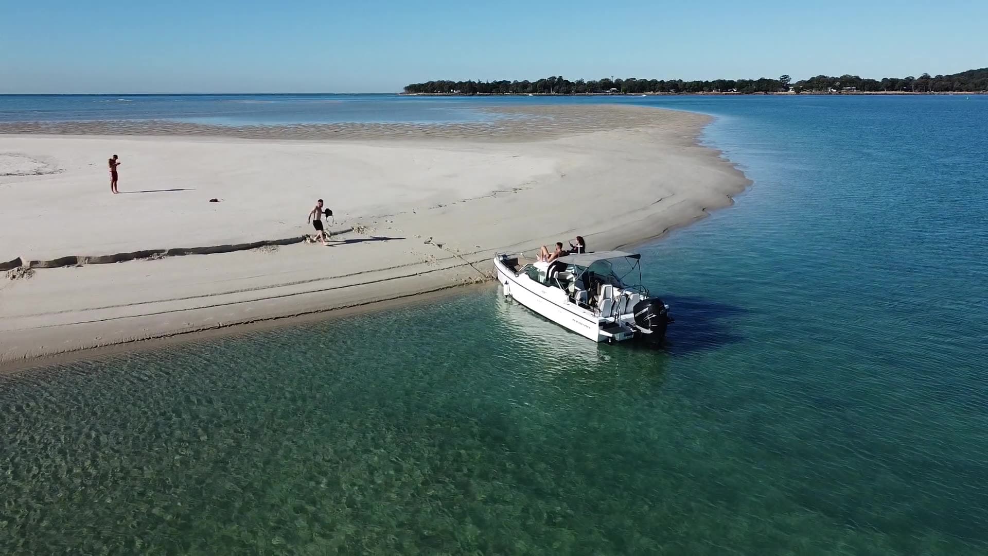 Aerial of guests beside the boat pulled up on a sandbar in the bay